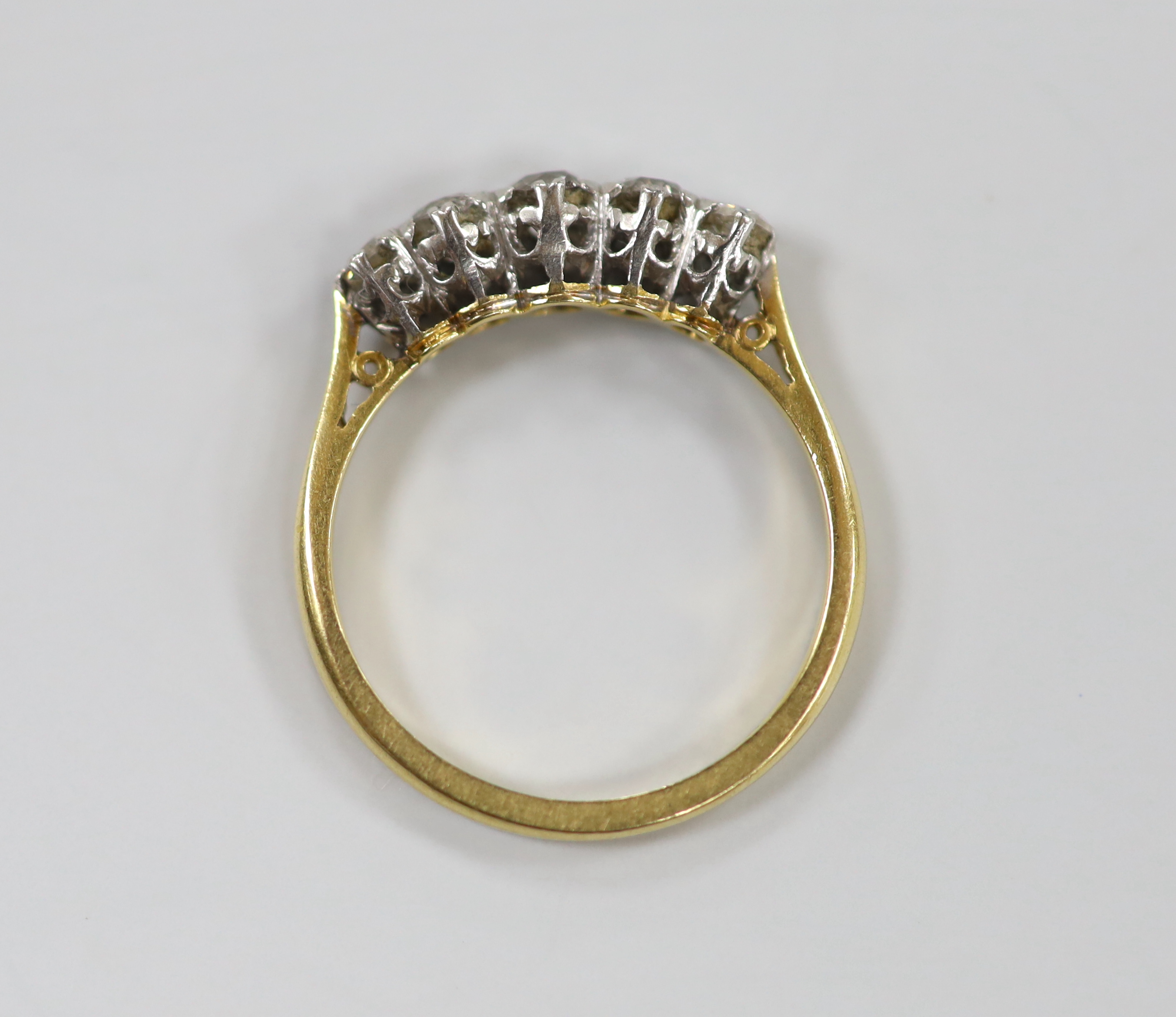 An 18ct, plat and graduated five stone diamond set half hoop ring, size M, gross weight 2.6 grams.